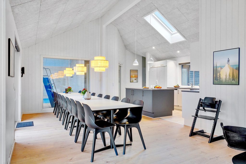Das Wohnzimmer mit moderner Einbauküche und Pool im Ferienhaus in Dänemark für bis zu 16 Personen