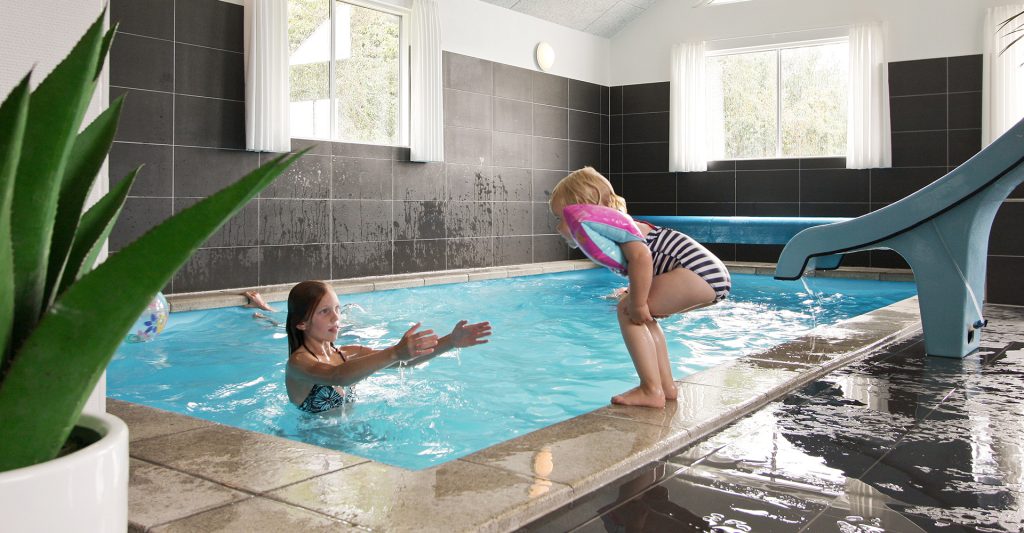 Kinder spielen im Pool vom Ferienhaus in Dänemark
