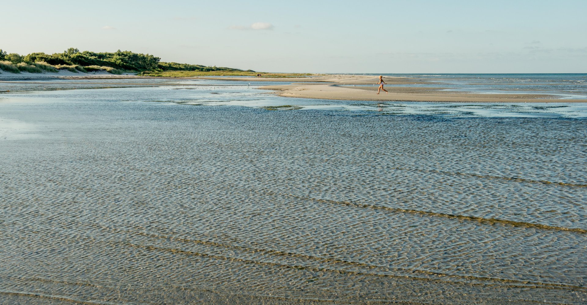 Kind spielt am Wasser bei Øster Hurup am Mariagerfjord, Dänemark