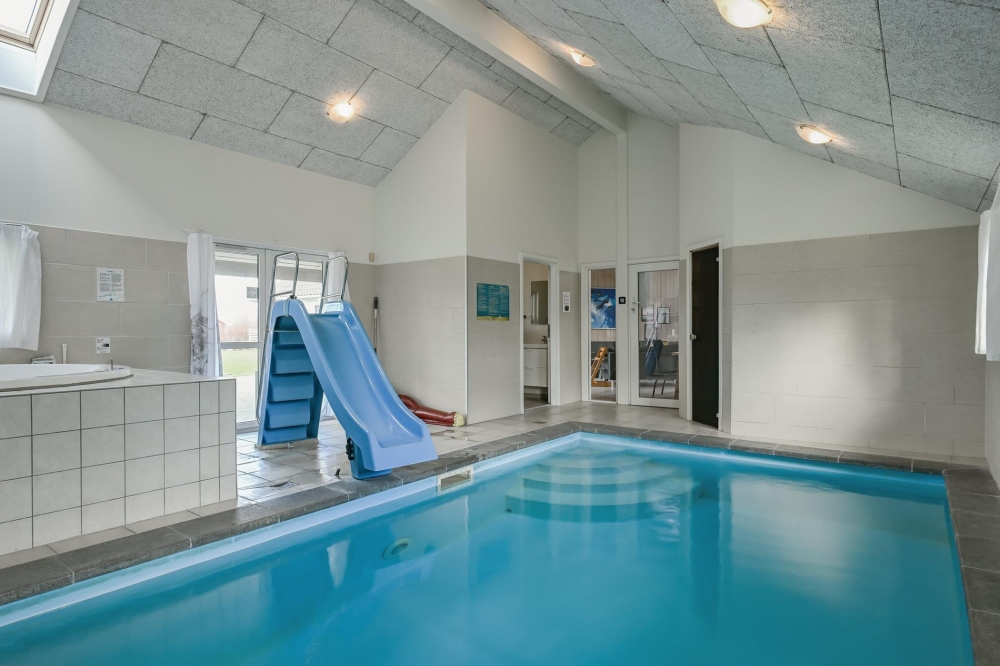 Das Ferienhaus 222 hat einen schicken Poolbereich mit Wasserrutsche, einem geräumigen, eingelassenen Whirlpool und einer Sauna.