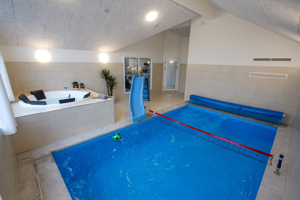 Das Ferienhaus 409 hat einen schicken Poolbereich mit Wasserrutsche, einem geräumigen, eingelassenen Whirlpool und einer Sauna.