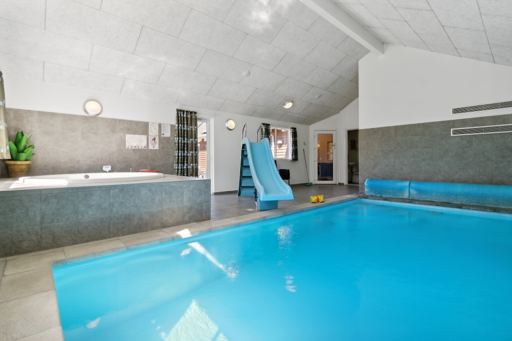 Das Ferienhaus 261 hat einen schicken Poolbereich mit Wasserrutsche, einem geräumigen, eingelassenen Whirlpool und einer Sauna.