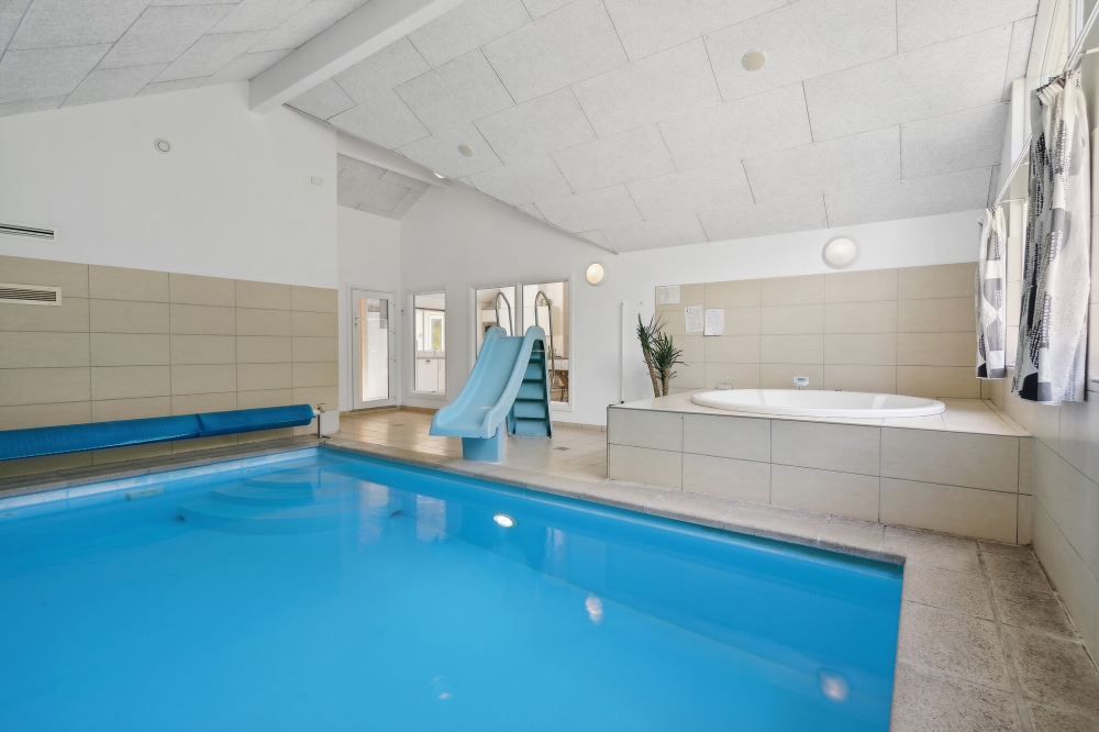 Das Ferienhaus 320 hat einen schicken Poolbereich mit Wasserrutsche, einem geräumigen, eingelassenen Whirlpool und einer Sauna.