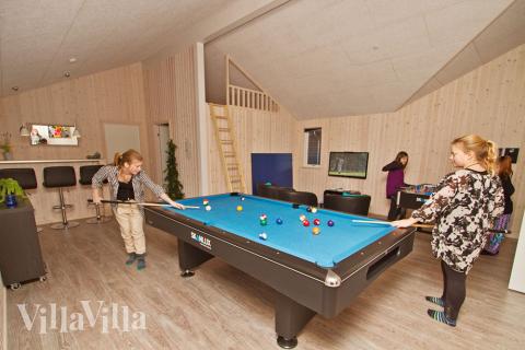 Sportliche Gäste treten im Aktivitätenraum gegeneinander in Billard/ Tischtennis, Kicker und Dart an