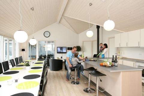 Das Haus hat einen großen Aufenthaltsraum mit Küche, Speiseplätzen und einer Sofagruppe mit Kaminofen