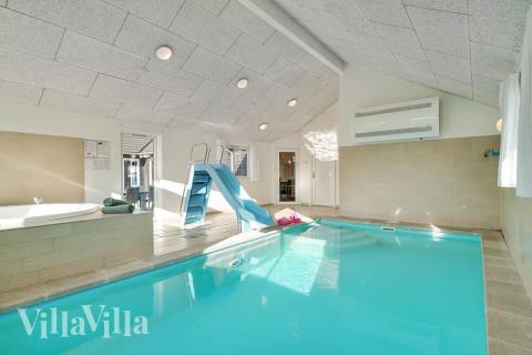 Das Ferienhaus 237 hat einen schicken Poolbereich mit Wasserrutsche, einem geräumigen, eingelassenen Whirlpool und einer Sauna.