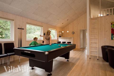 Sportliche Gäste treten im Aktivitätenraum gegeneinander in Billard/ Tischtennis, Kicker und Dart an