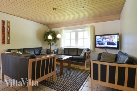 Einer der gemütlichen Aufenthaltsräume des Hauses ist mit Ledermöbeln und einem gemütlichen Kaminofen ausgestattet