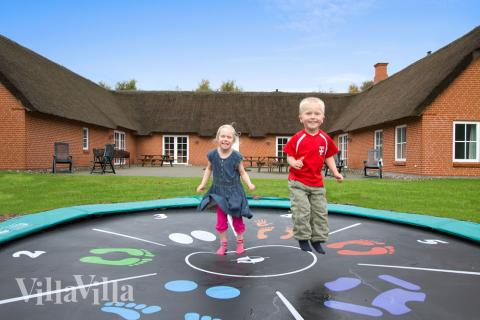 Die einladende, große Fliesenterrasse liegt gut geschützt zwischen den Langseiten des Hauses