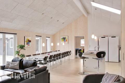 Die zentral platzierte Wohnküche ist mit einer geräumigen Kochecke, Speiseplätzen und einer Sofagruppe mit kuscheligem Kaminofen ausgestattet