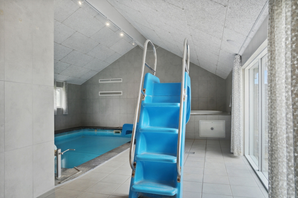 Das Ferienhaus 212 hat einen schicken Poolbereich mit Wasserrutsche, einem geräumigen, eingelassenen Whirlpool und einer Sauna.