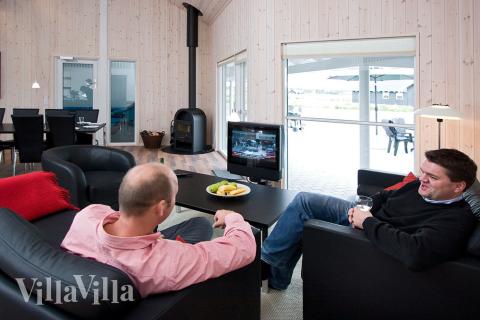 Die bequemen Möbel, der Flachbildfernseher und der Kaminofen im Aufenthaltsraum laden zu Gemütlichkeit und Entspannung ein