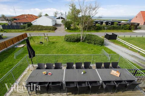 Auf der großen Terrasse des Hauses kann man das Sommerwetter genießen, während die Kinder im Garten spielen