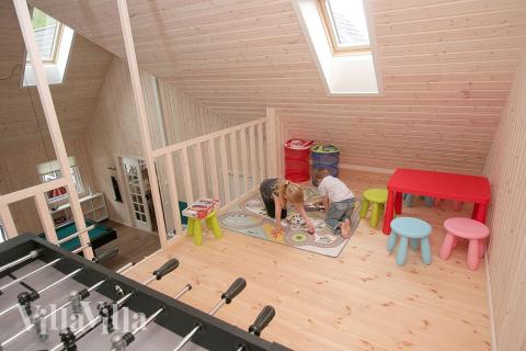 Unter dem Dach befindet sich die Kinderecke mit Autoteppich, Kicker und Kindermöbeln