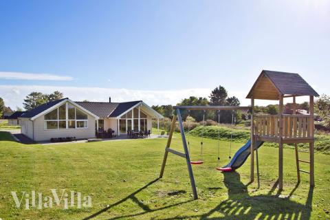Auf dem Grundstück des Hauses befinden sich ein Schaukelstativ und eine Sandkiste. Somit können die Kinder spielen, während andere Familienmitglieder die Sonne auf der großen Terrasse des Hauses genießen