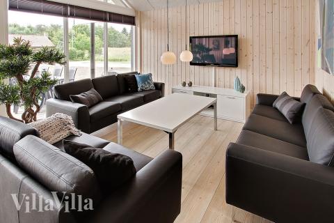 Das Wohnzimmer ist gemütlich eingerichtet mit Sofa und Kaminofen, welcher an kalten Tagen für extra Wärme und Gemütlichkeit sorgt