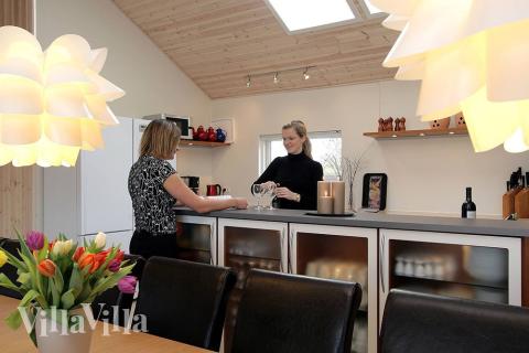 Im zentralen Raum des Hauses befindet sich die Küche in direkter, offener Verbindung zum Wohnzimmer. In dieser geräumigen Wohnküche mit Sofagruppe und Esstisch kann also auch während des Kochens herrlich geklönt werden