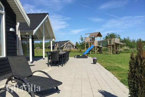 Die teilüberdachte Terrasse ist perfekt für einen Sommertag oder einen Grillabend. Die kleinsten Gäste freuen sich über Sandkiste und Schaukel 