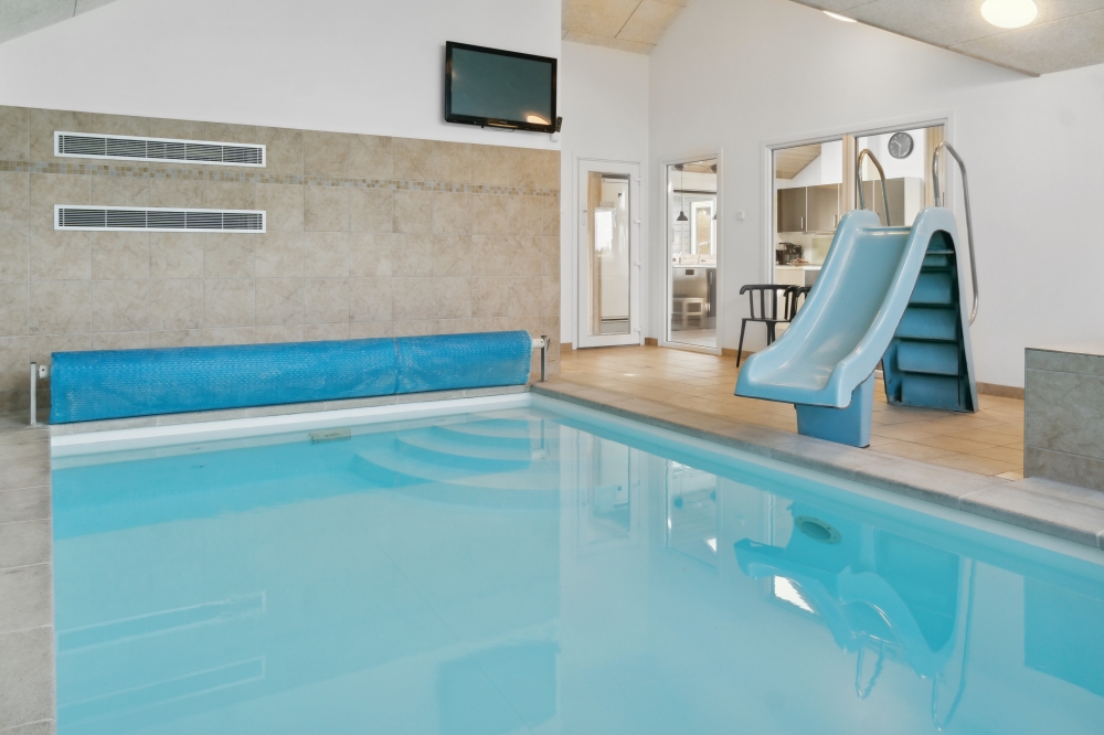 Das Ferienhaus 282 hat einen schicken Poolbereich mit Wasserrutsche, einem geräumigen, eingelassenen Whirlpool und einer Sauna.