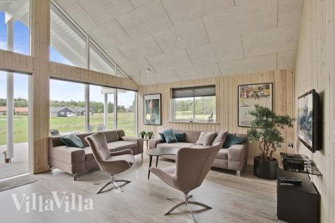 Die Sofagruppe ist mit bequemen Möbeln, Kaminofen und Fernseher eingerichtet