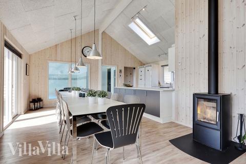 In dem Wohnzimmer finden Sie eine gemütliche Sitzecke, einen Holzofen, und einen großen Esstisch, an dem alle Gäste mit Blick auf den Poolbereich zusammen sitzen können.