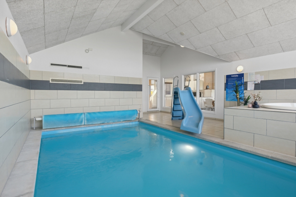 Das Ferienhaus 345 hat einen schicken Poolbereich mit Wasserrutsche, einem geräumigen, eingelassenen Whirlpool und einer Sauna.