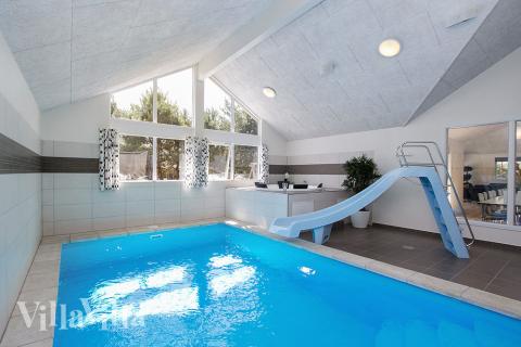 Das Ferienhaus 347 hat einen schicken Poolbereich mit Wasserrutsche, einem geräumigen, eingelassenen Whirlpool und einer Sauna.