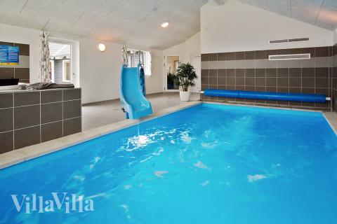 Das Ferienhaus 703 hat einen schicken Poolbereich mit Wasserrutsche, einem geräumigen, eingelassenen Whirlpool und einer Sauna.