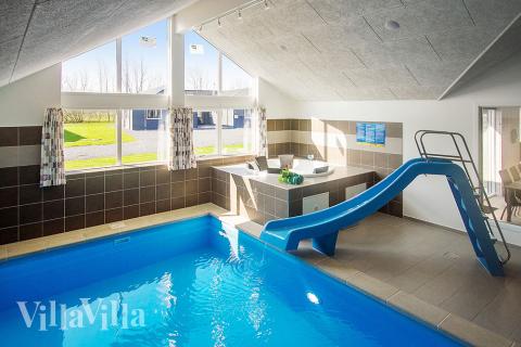 Das Ferienhaus 704 hat einen schicken Poolbereich mit Wasserrutsche, einem geräumigen, eingelassenen Whirlpool und einer Sauna.