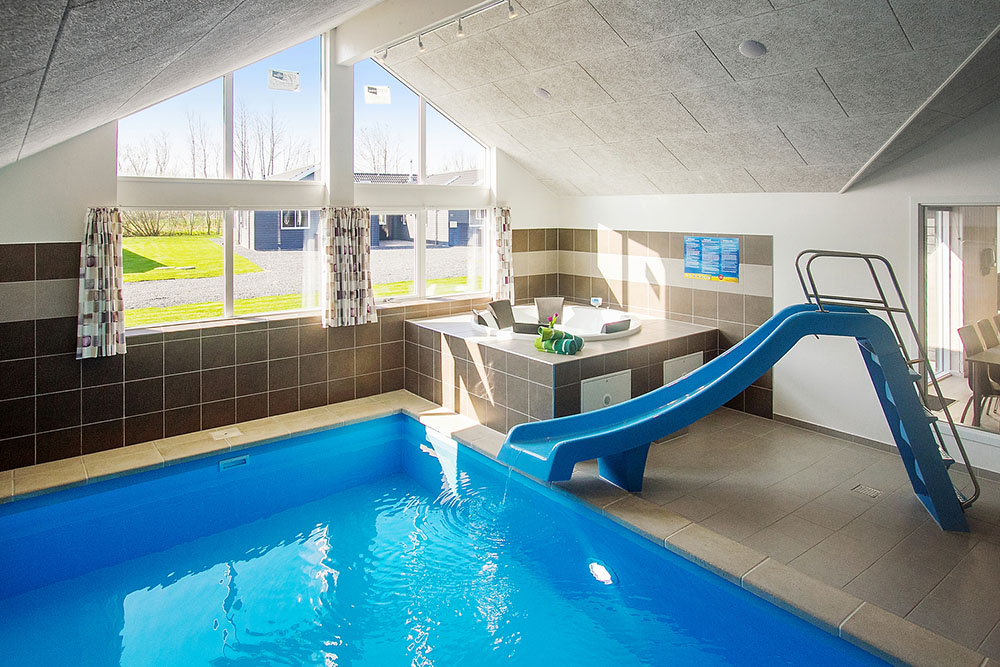 Das Ferienhaus 704 hat einen schicken Poolbereich mit Wasserrutsche, einem geräumigen, eingelassenen Whirlpool und einer Sauna.