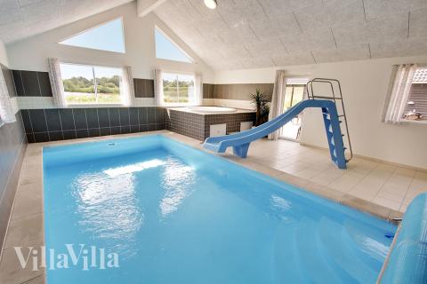 Das Ferienhaus 395 hat einen schicken Poolbereich mit Wasserrutsche, einem geräumigen, eingelassenen Whirlpool und einer Sauna.