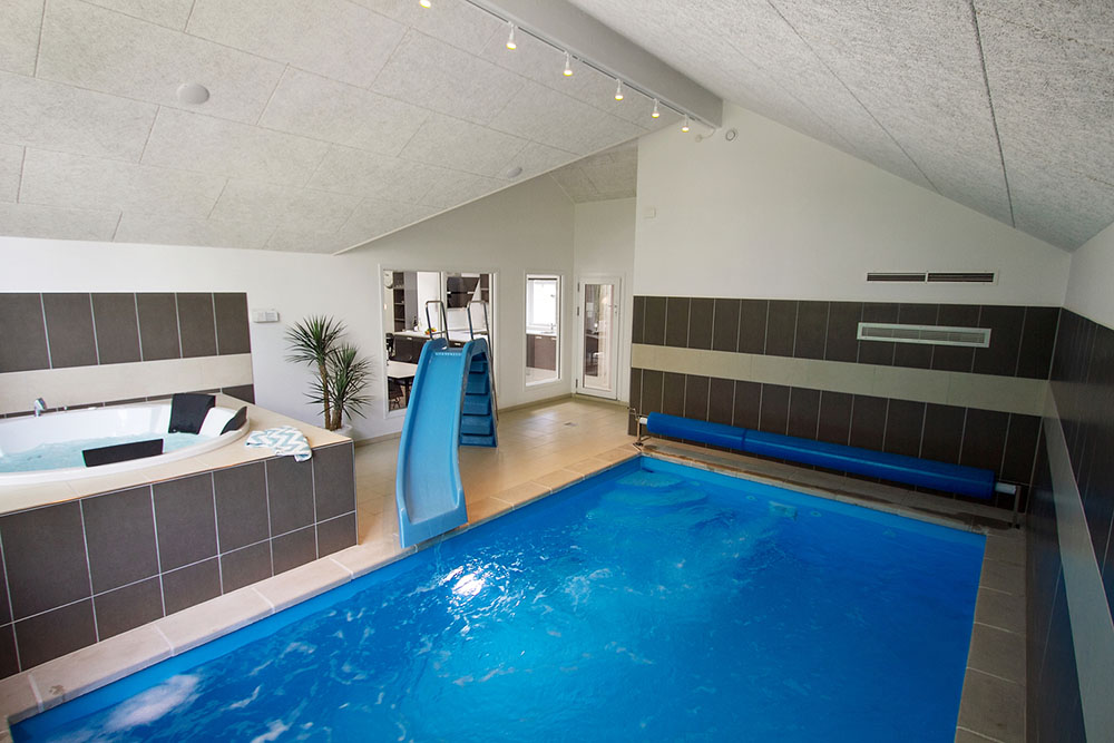 Das Ferienhaus 713 hat einen schicken Poolbereich mit Wasserrutsche, einem geräumigen, eingelassenen Whirlpool und einer Sauna.