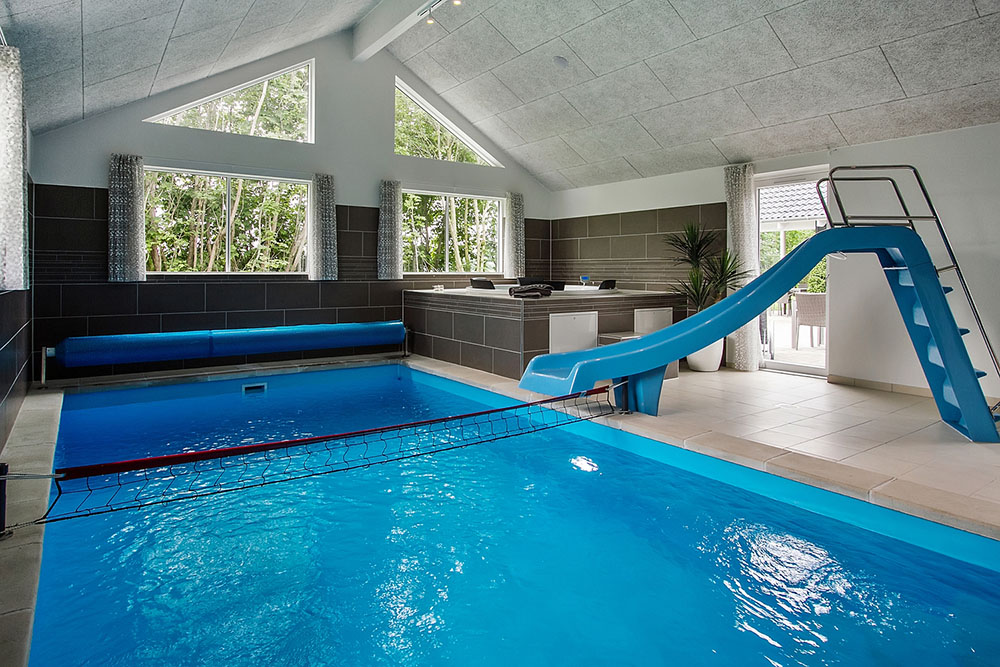 Das Ferienhaus 715 hat einen schicken Poolbereich mit Wasserrutsche, einem geräumigen, eingelassenen Whirlpool und einer Sauna.