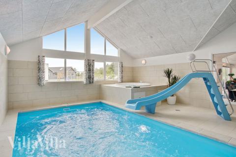 Das Ferienhaus 390 hat einen schicken Poolbereich mit Wasserrutsche, einem geräumigen, eingelassenen Whirlpool und einer Sauna.