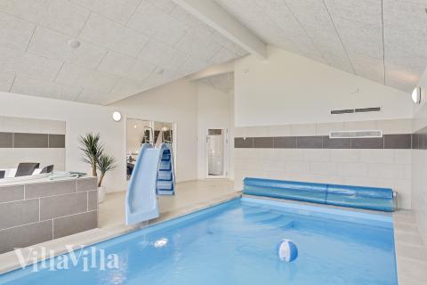 Das Ferienhaus 405 hat einen schicken Poolbereich mit Wasserrutsche, einem geräumigen, eingelassenen Whirlpool und einer Sauna.