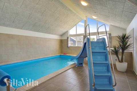 Das Ferienhaus 717 hat einen schicken Poolbereich mit Wasserrutsche, einem geräumigen, eingelassenen Whirlpool und einer Sauna.