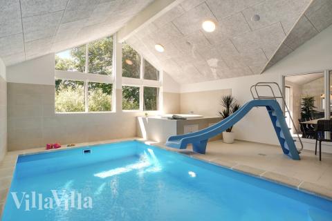 Das Ferienhaus 720 hat einen schicken Poolbereich mit Wasserrutsche, einem geräumigen, eingelassenen Whirlpool und einer Sauna.