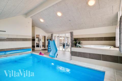Das Ferienhaus 465 hat einen schicken Poolbereich mit Wasserrutsche, einem geräumigen, eingelassenen Whirlpool und einer Sauna.