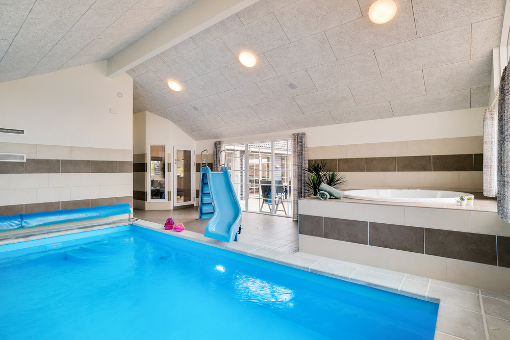 Das Ferienhaus 465 hat einen schicken Poolbereich mit Wasserrutsche, einem geräumigen, eingelassenen Whirlpool und einer Sauna.