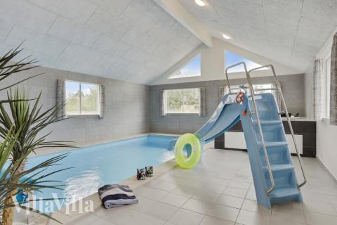 Das Ferienhaus 445 hat einen schicken Poolbereich mit Wasserrutsche, einem geräumigen, eingelassenen Whirlpool und einer Sauna.