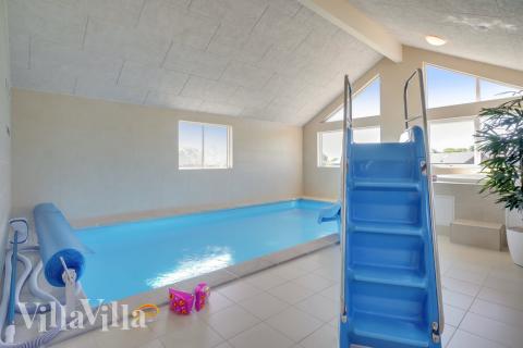 Das Ferienhaus 493 hat einen schicken Poolbereich mit Wasserrutsche, einem geräumigen, eingelassenen Whirlpool und einer Sauna.