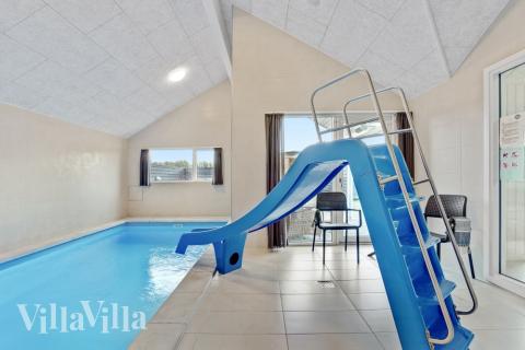 Das Ferienhaus 553 hat einen schicken Poolbereich mit Wasserrutsche, einem geräumigen, eingelassenen Whirlpool und einer Sauna.