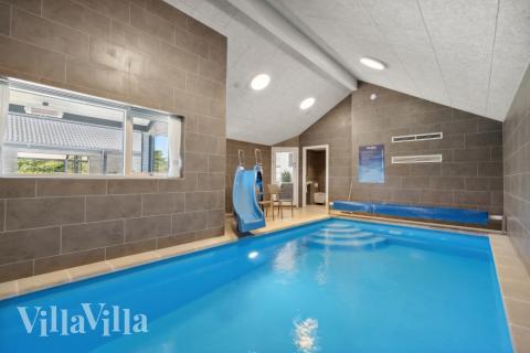 Das Ferienhaus 596 hat einen schicken Poolbereich mit Wasserrutsche, einem geräumigen, eingelassenen Whirlpool und einer Sauna.