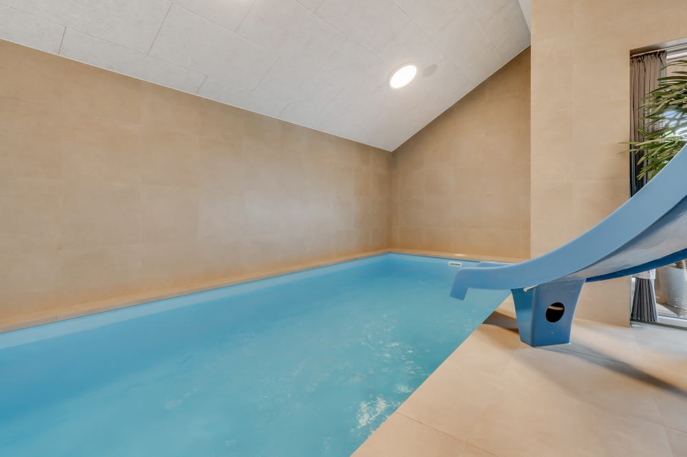 Das Ferienhaus 599 hat einen schicken Poolbereich mit Wasserrutsche, einem geräumigen, eingelassenen Whirlpool und einer Sauna.