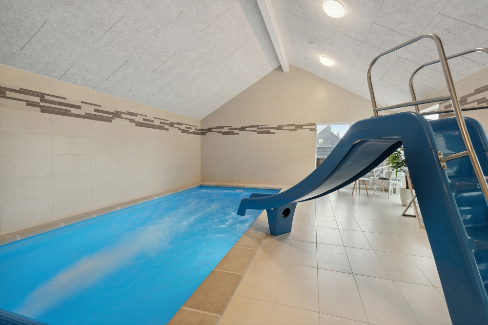 Das Ferienhaus 600 hat einen schicken Poolbereich mit Wasserrutsche, einem geräumigen, eingelassenen Whirlpool und einer Sauna.