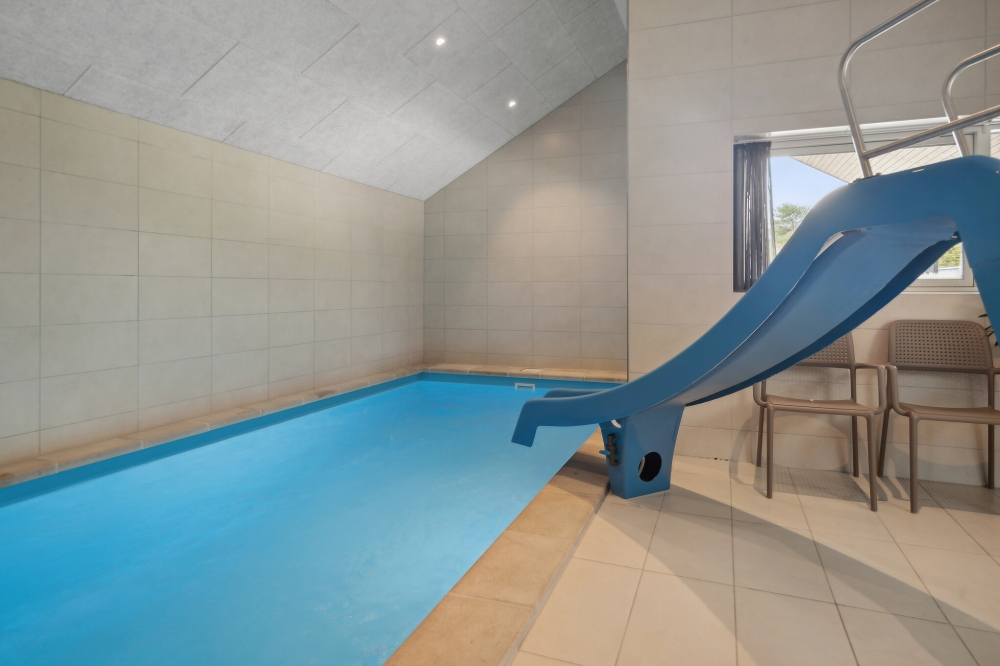 Das Ferienhaus 595 hat einen schicken Poolbereich mit Wasserrutsche, einem geräumigen, eingelassenen Whirlpool und einer Sauna.