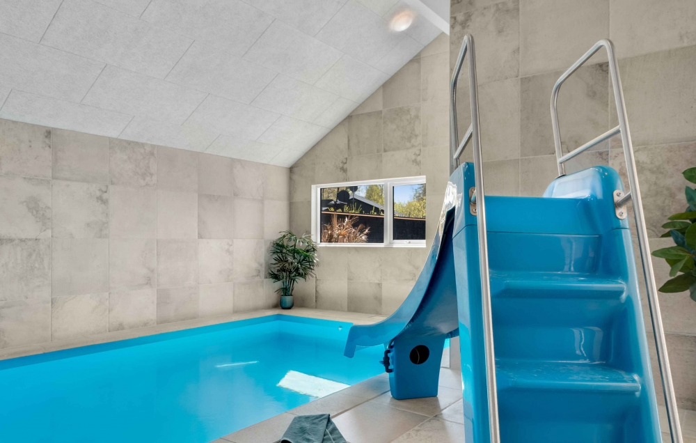Das Ferienhaus 582 hat einen schicken Poolbereich mit Wasserrutsche, einem geräumigen, eingelassenen Whirlpool und einer Sauna.