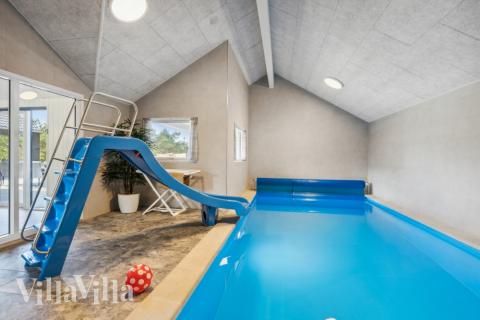 Das Ferienhaus 585 hat einen schicken Poolbereich mit Wasserrutsche, einem geräumigen, eingelassenen Whirlpool und einer Sauna.