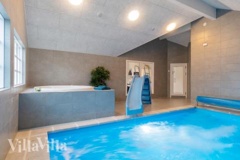 Das Ferienhaus 810 hat einen schicken Poolbereich mit Wasserrutsche, einem geräumigen, eingelassenen Whirlpool und einer Sauna.