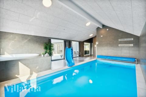 Das Ferienhaus 814 hat einen schicken Poolbereich mit Wasserrutsche, einem geräumigen, eingelassenen Whirlpool und einer Sauna.